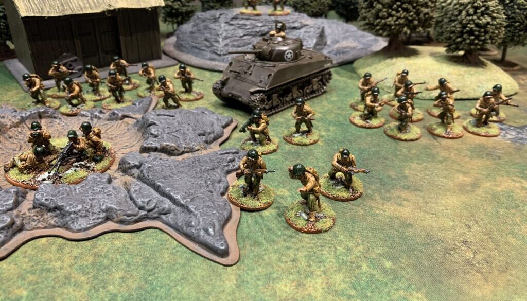 Photo of an approximately 650 point force of American Bolt Action miniatures with a farmhouse, forest, rock, and crater I the background.