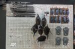 Top-down photo of my cleaned-up paint table featuring only a rack of brushes and three projects: some Slaanesh cavalry, some war hounds of chaos, and a quartet of Kratos tanks for Legions Imperialis.